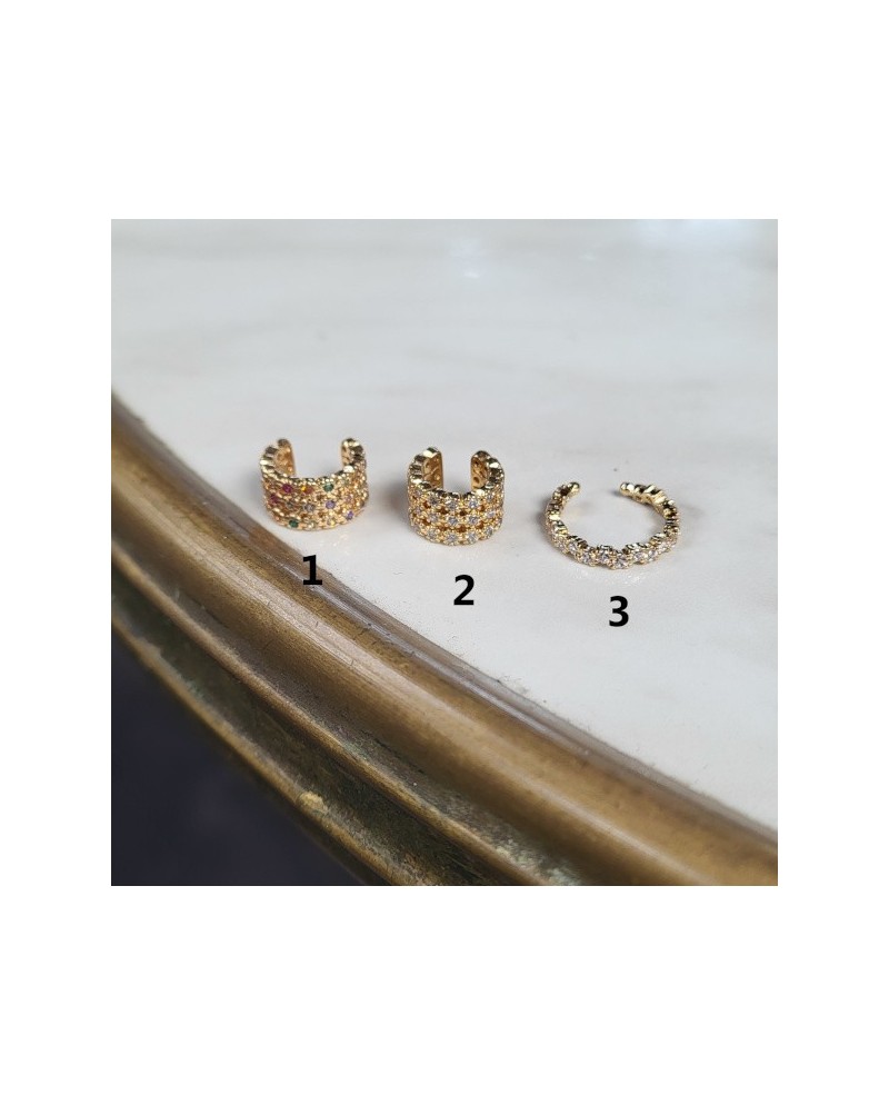 ear cuffs dorée ajourée, avec des motifs arrondis et de petits strass colorés. Un modèle original au style travaillé.